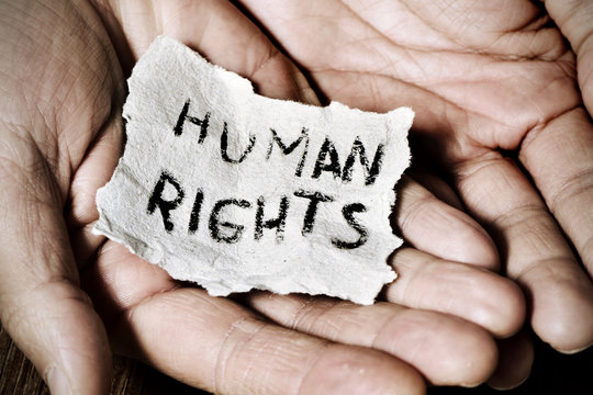 Hands holding a note labelled human rights.